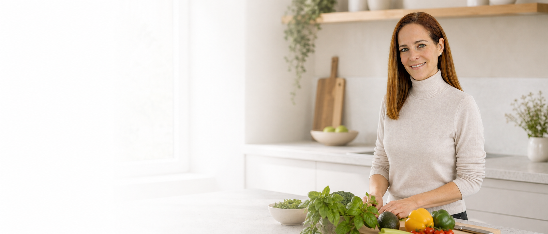 Valentina hinter einer Kücheninsel mit frischen Kräutern und Gemüse