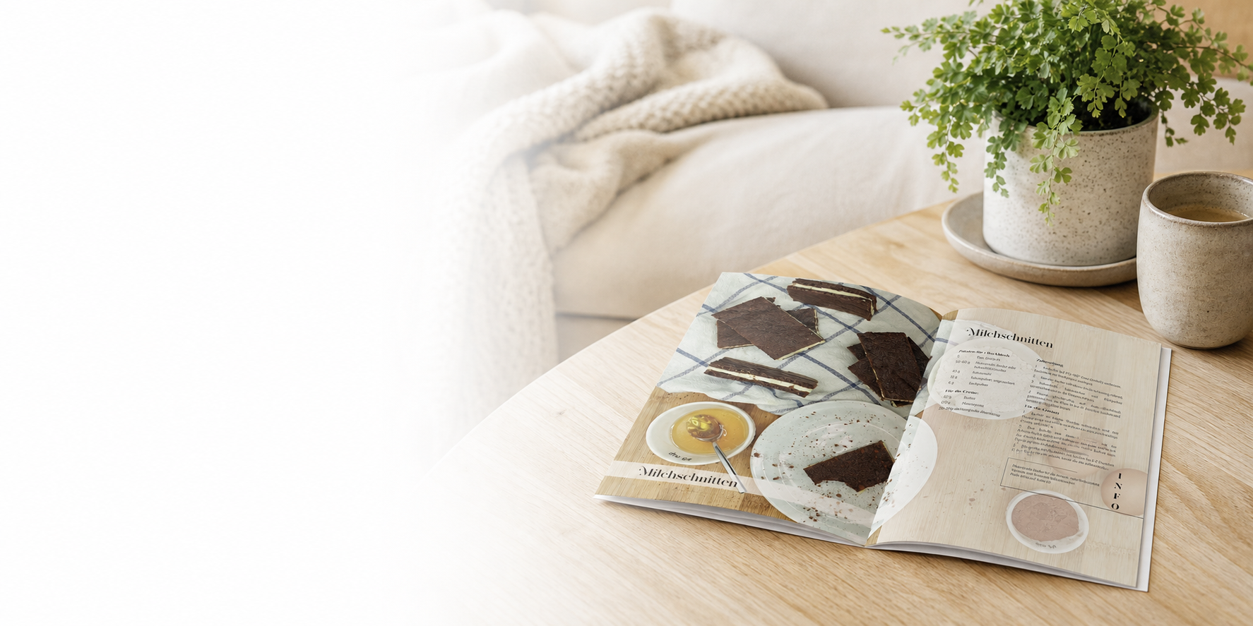 Geöffnetes Rezeptbuch auf einem hellen Holztisch in einer ruhigen Leseecke